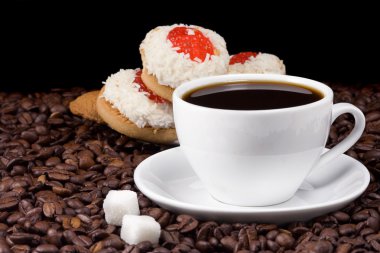 Cup and cookies on coffee beans