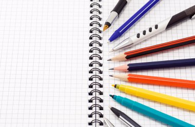 Pens and pencils on notebook clipart