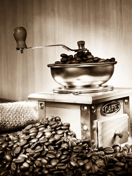 Grãos de café e moedor em saquear em sépia — Fotografia de Stock