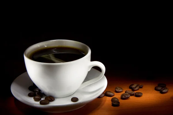 Siyah arka planda bir fincan kahve ve fasulye. — Stok fotoğraf
