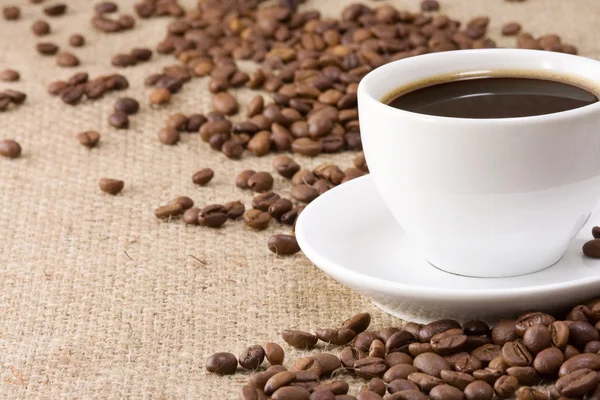 Cup of coffee, beans on sacking — Stock Photo, Image