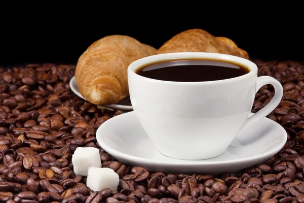 Kaffee und Croissant auf Bohnen — Stockfoto