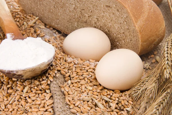 Eggs, bread and spoon on sacking — Stock Photo, Image