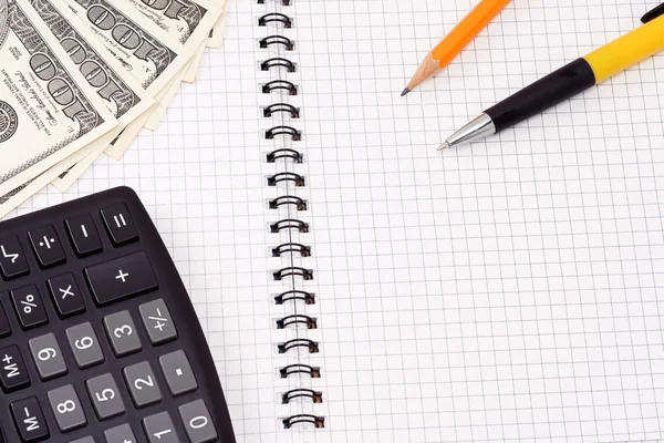 Ручка, пенсил, калькулятор и доллары на блокноте — стоковое фото