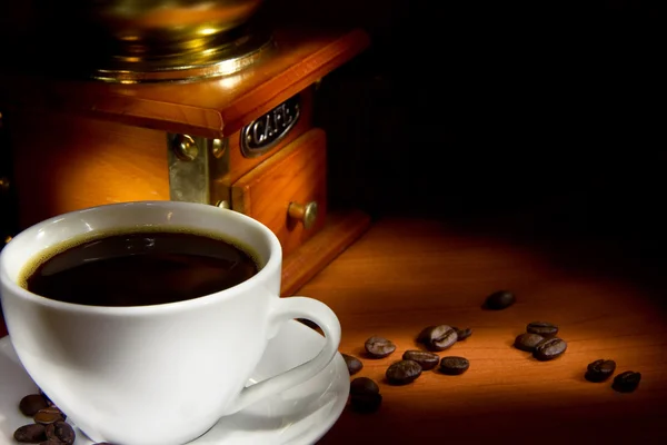 Kopp kaffe, bönor och kvarnen på svart bakgrund — Stockfoto