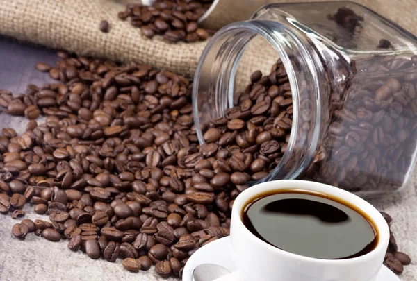 Xícara de café, jarra e potfull de grãos no saco — Fotografia de Stock