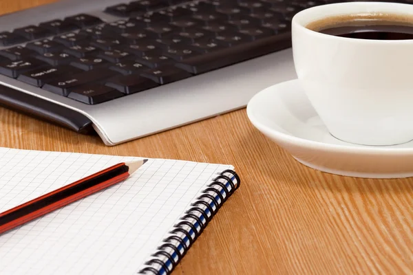 Teclado, caderno e xícara de café — Fotografia de Stock