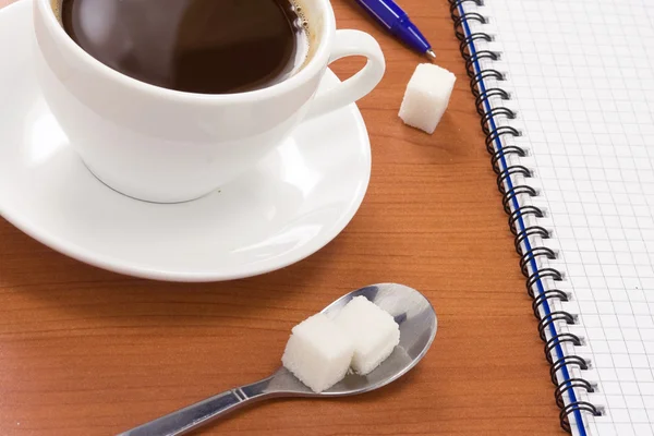 Gecontroleerd notebook en koffie met pen — Stockfoto