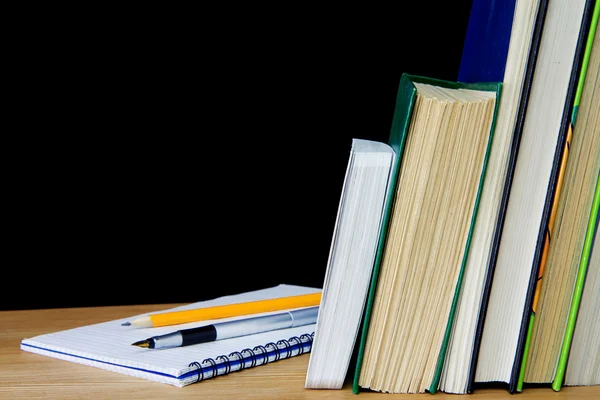 Stift und Bleistift auf Notizbuch in der Nähe von Büchern — Stockfoto