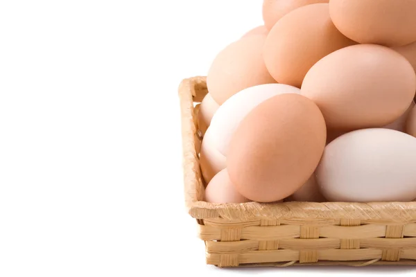 Яйца в плетеной корзине изолированы на белом — стоковое фото