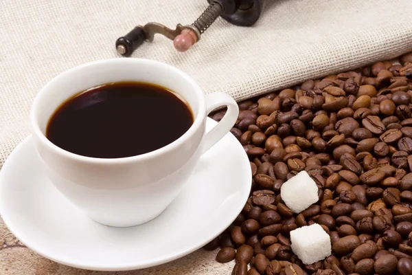 Tasse Kaffee, Bohnen und Mühle im Sack — Stockfoto