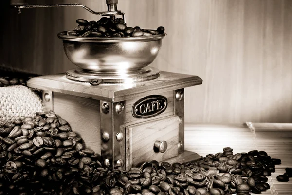 Coffee beans and grinder on sacking in sepia — Stock Photo, Image