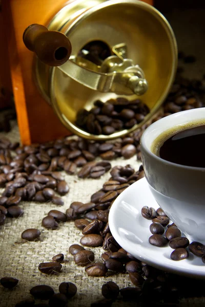 Cup of coffee, beans and grinder on sacking — Stock Photo, Image