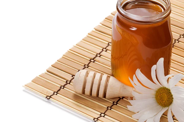 Pot of honey and flower isolated on white — Stock Photo, Image