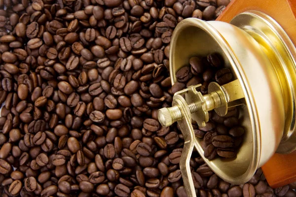 Koffiebonen en gouden grinder — Stockfoto