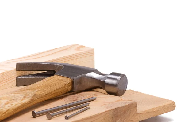 Hammer und Nagel isoliert auf Holz — Stockfoto