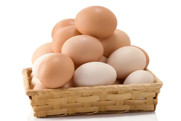 Huevos en canasta de mimbre sobre blanco —  Fotos de Stock