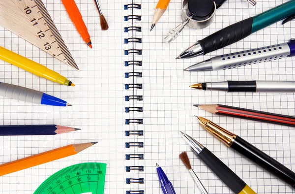 Ручки и карандаши на ноутбуке — стоковое фото