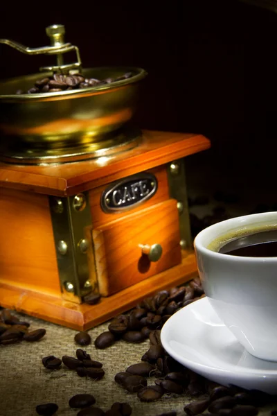 Kopje koffie, bonen en grinder op plundering — Stockfoto
