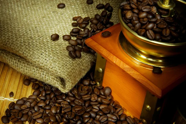 Kaffebönor och kvarnen på säckväv — Stockfoto