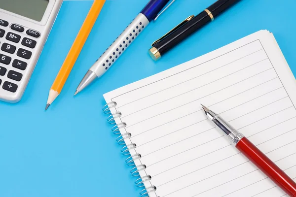Lápis, calculadora e caneta no bloco de notas — Fotografia de Stock