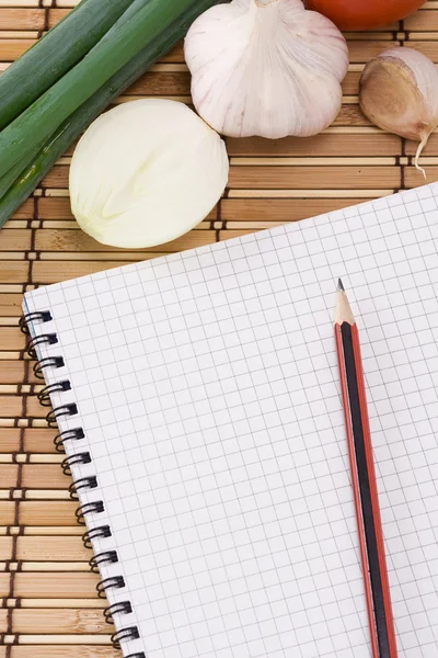 Notizbuch mit Bleistift, Knoblauch, Tomate und Zwiebel auf Stroh Textur — Stockfoto