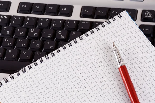 Bloco de notas e lápis no teclado — Fotografia de Stock