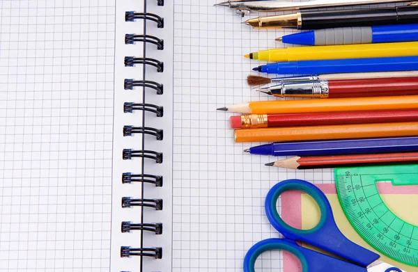 Bolígrafos, lápices y accesorios de oficina en el cuaderno —  Fotos de Stock