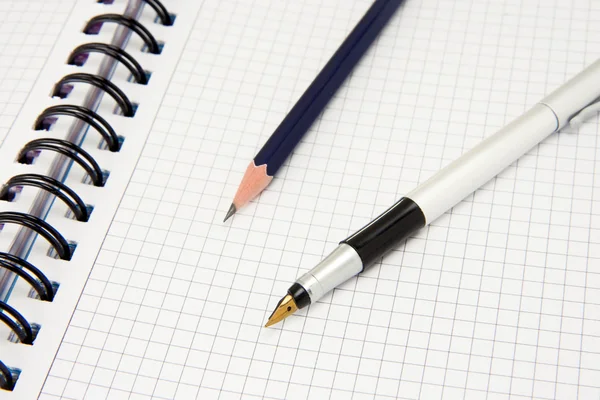 Ручка и карандаш на блокноте — стоковое фото