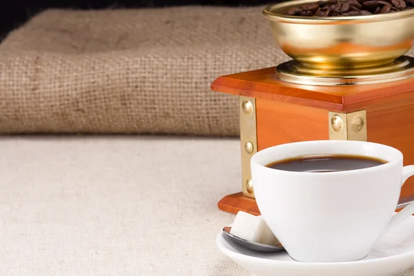 Fincan kahve ve öğütücü çuval üzerinde — Stok fotoğraf