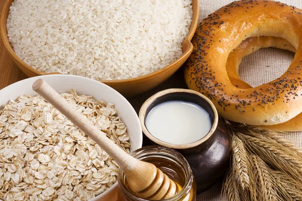 Rice, oat, honey, milk and spike on sack — Stock Photo, Image