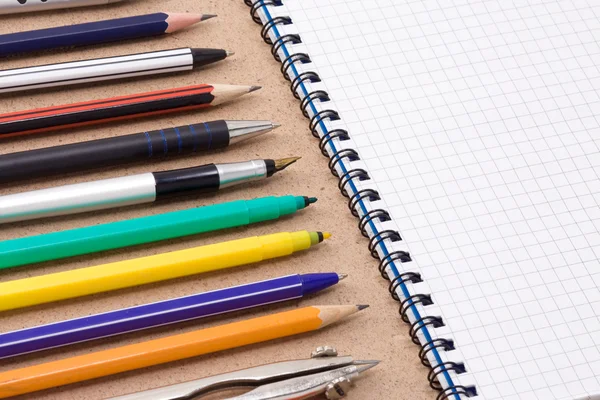 Bolígrafo, lápiz y rotulador cerca del cuaderno — Foto de Stock