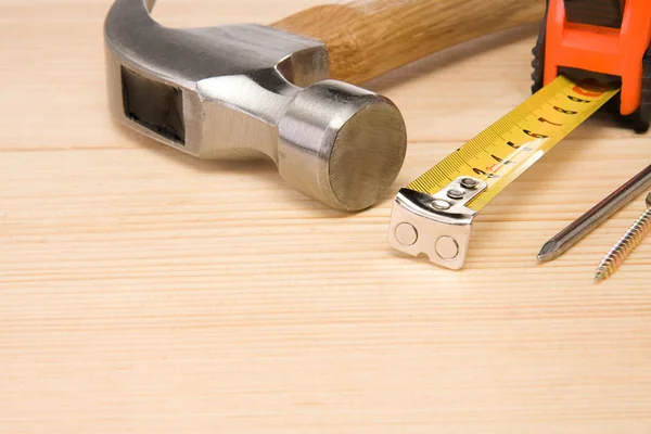 Hamer, lintmeter en spijker op hout — Stockfoto