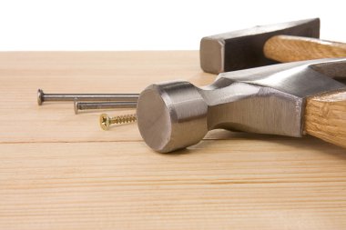 Isolated hammer and nail on wood bar clipart