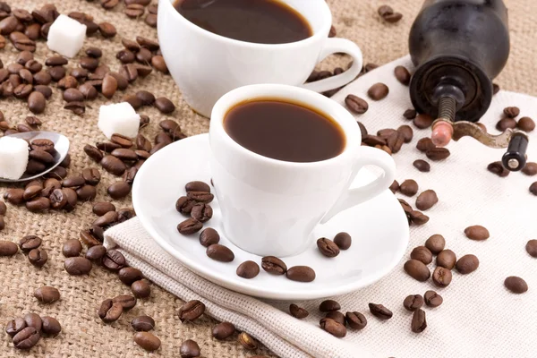 Beans, sugar and cup of coffee on sack — Stock Photo, Image