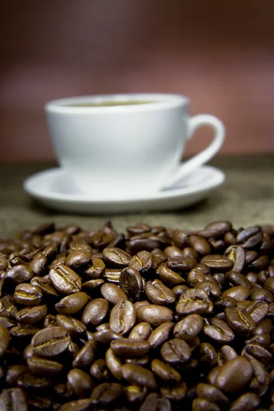 Xícara de café e feijão no saco — Fotografia de Stock