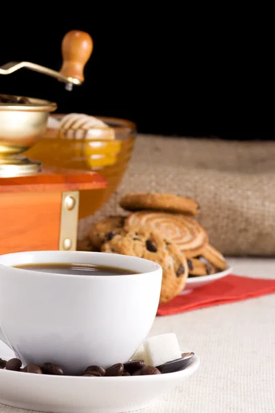Granos de café, taza y molinillo en el saqueo —  Fotos de Stock