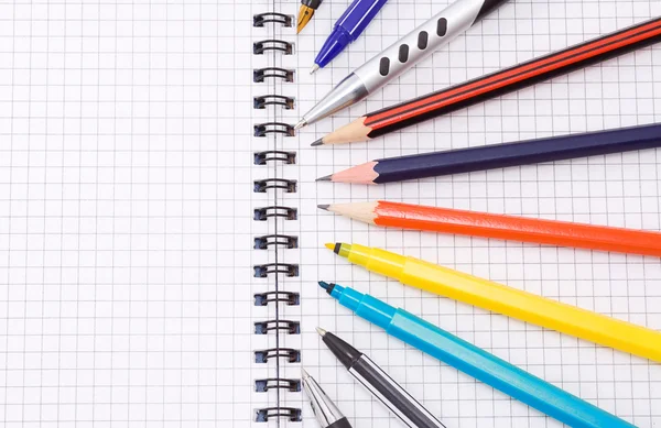 Ручка и карандаш на ноутбуке — стоковое фото