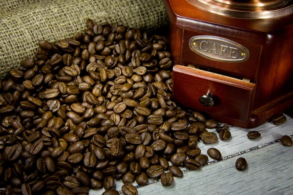 Grãos de café e moedor de madeira em sacos — Fotografia de Stock