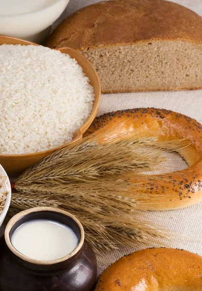 Bread, rice, milk and spike on sack — Stock Photo, Image