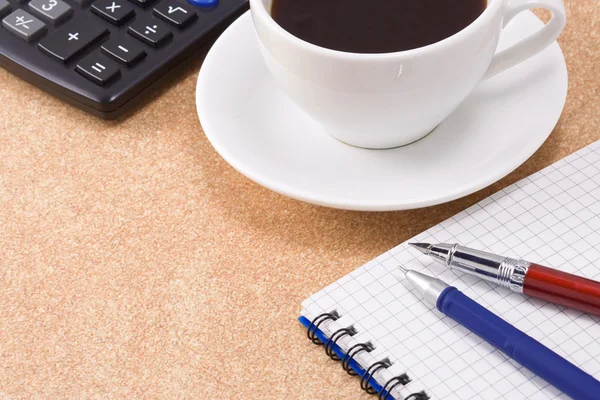 Ручка, карандаш и чашка кофе на блокноте — стоковое фото
