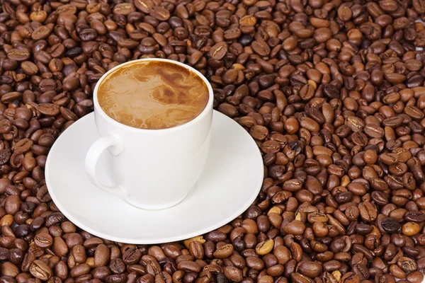 Granos de café y taza de bebida —  Fotos de Stock
