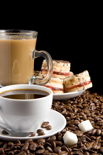 Xícara de café, feijão e doces em preto — Fotografia de Stock