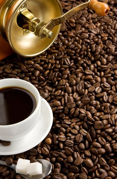 Kopje koffie en lepel op geroosterde bonen — Stockfoto