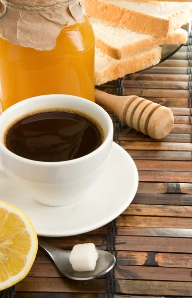 Coffee, honey, lemon and bread on table — Stock Photo, Image