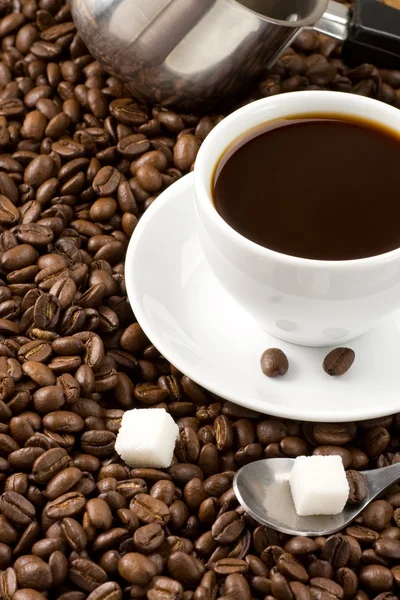 Чашка кофе и ложка на жареных бобах — стоковое фото