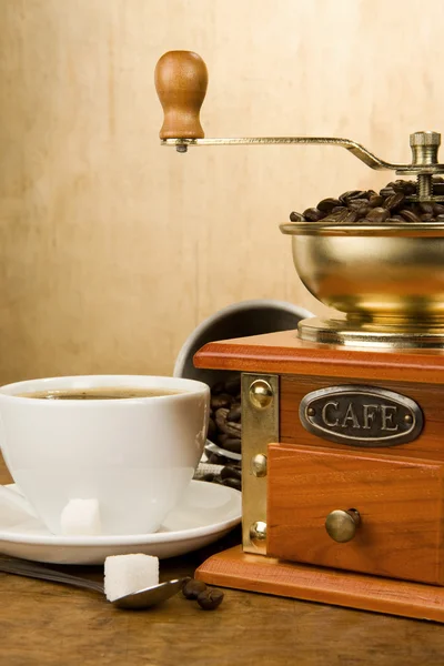 Xícara cheia de café, feijão, panela e moedor — Fotografia de Stock