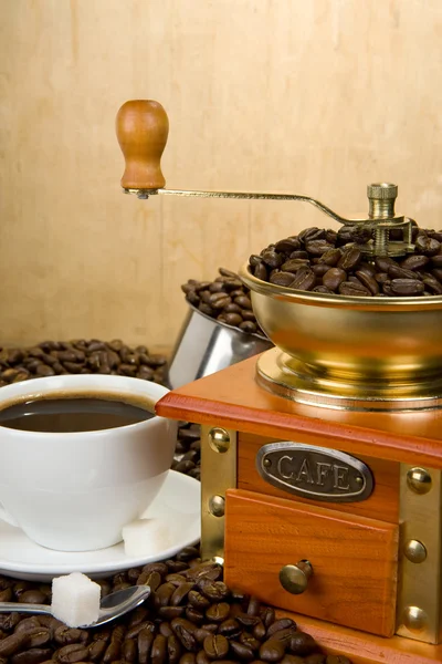 Grãos de café, xícara e moedor em madeira — Fotografia de Stock