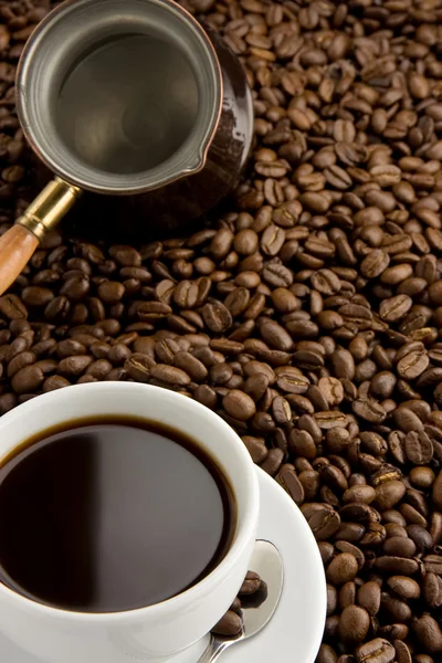 Taza de café y olla en granos tostados —  Fotos de Stock
