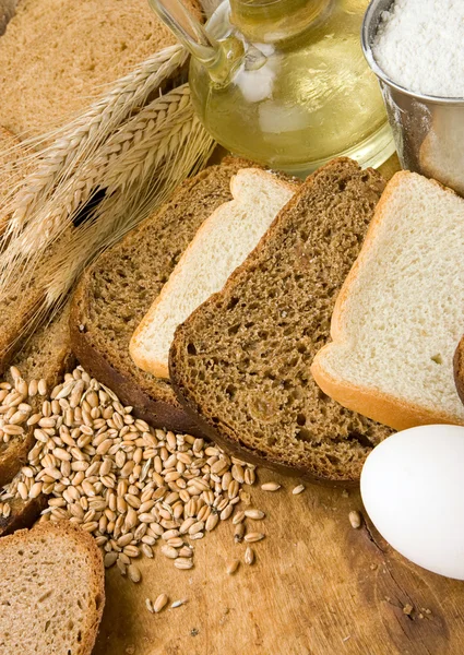 Bakkerijproducten en graan op hout — Stockfoto
